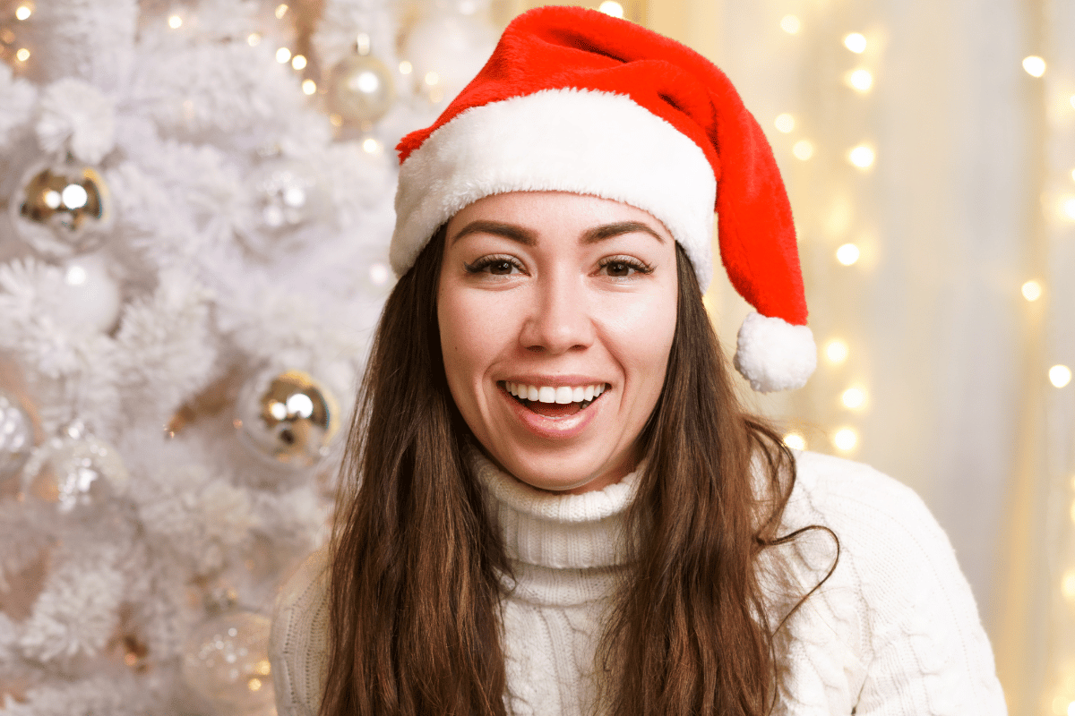 beautiful women smiling wearing christmas cap