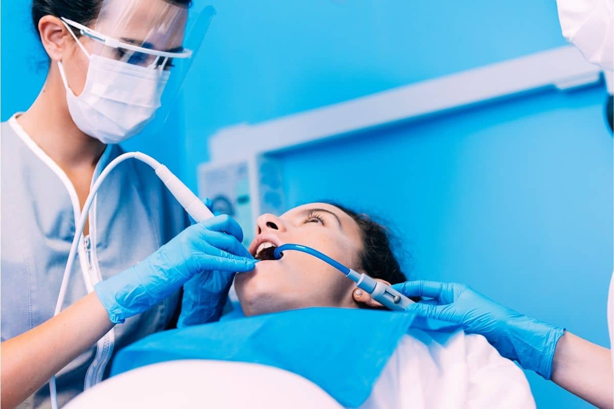 Dentist examining patient's teeth during sedation dental procedure in Albuquerque.