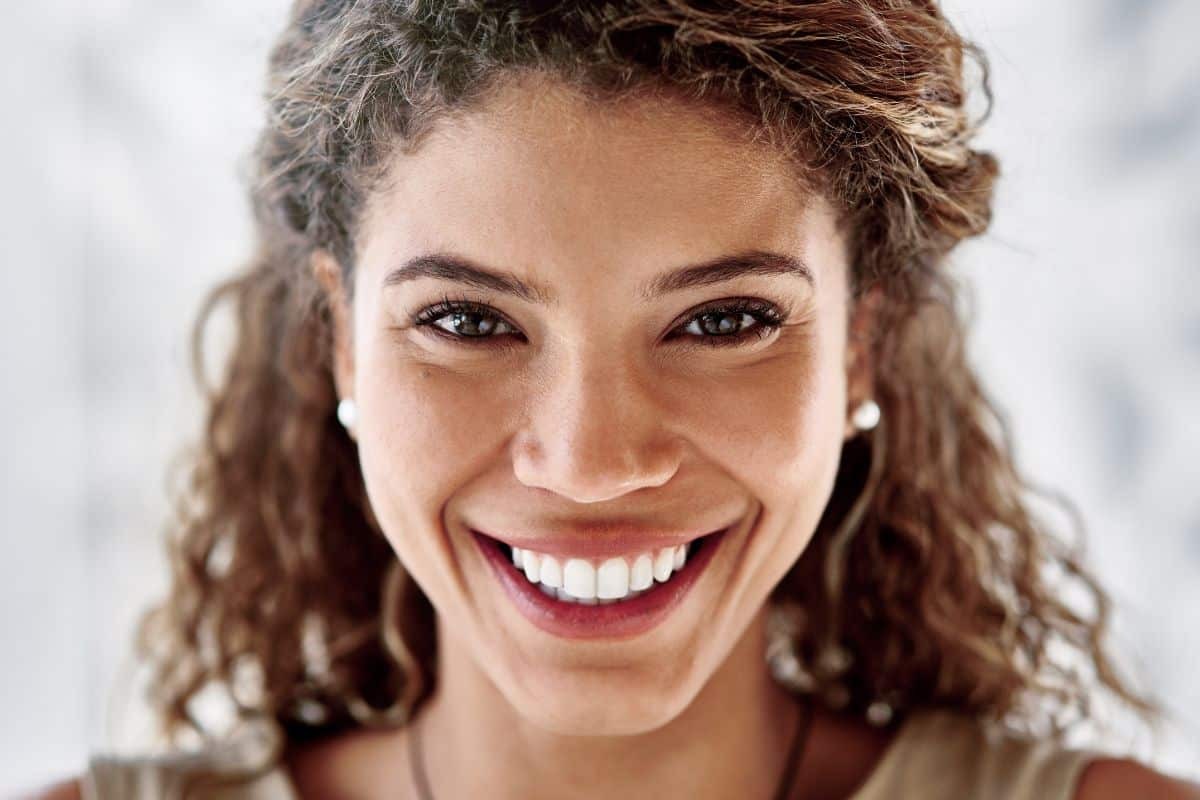 Smiling woman with bright white teeth showcasing cosmetic dental results.