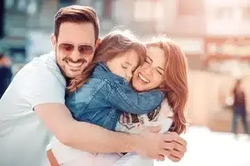 Happy family smiling together outdoors, representing quality dental care for all ages in Albuquerque.