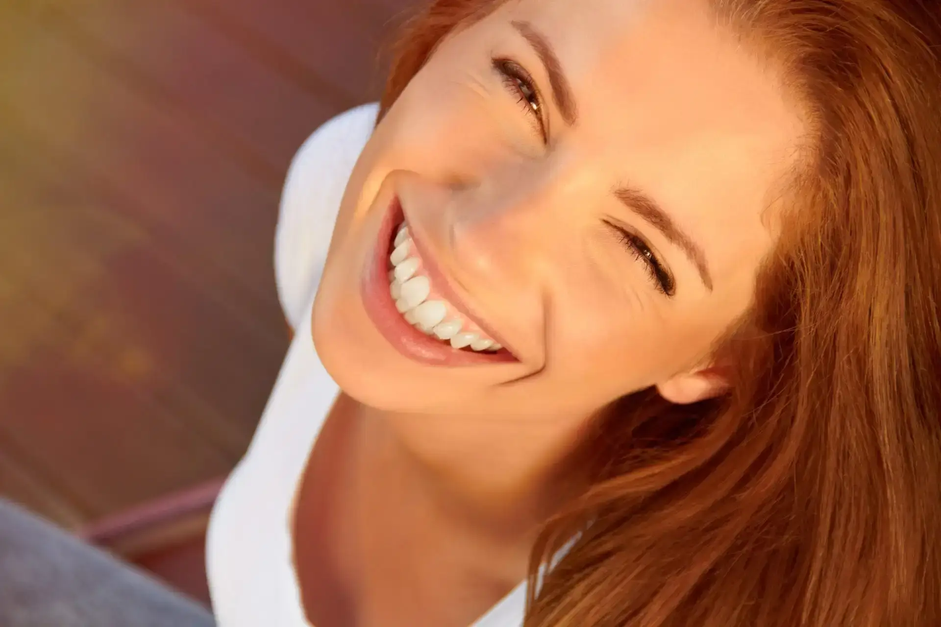Woman with bright white teeth smiling, showcasing dental restoration results in Albuquerque.