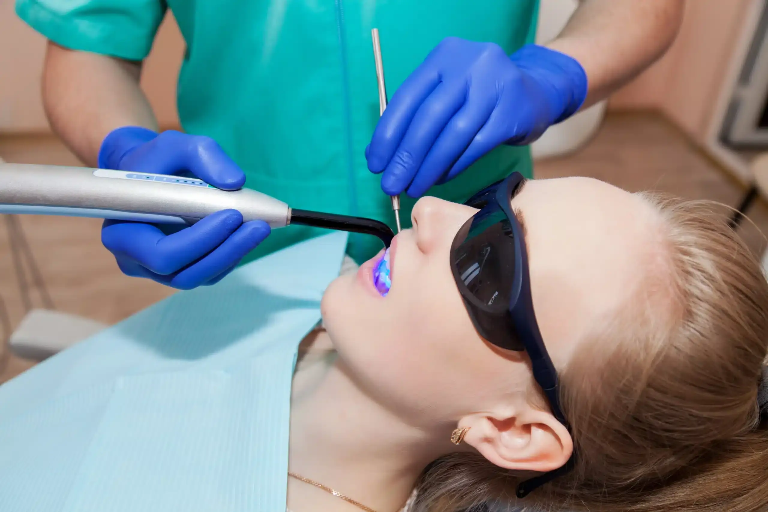 Child receiving dental treatment with UV curing light at Albuquerque sedation dental practice.