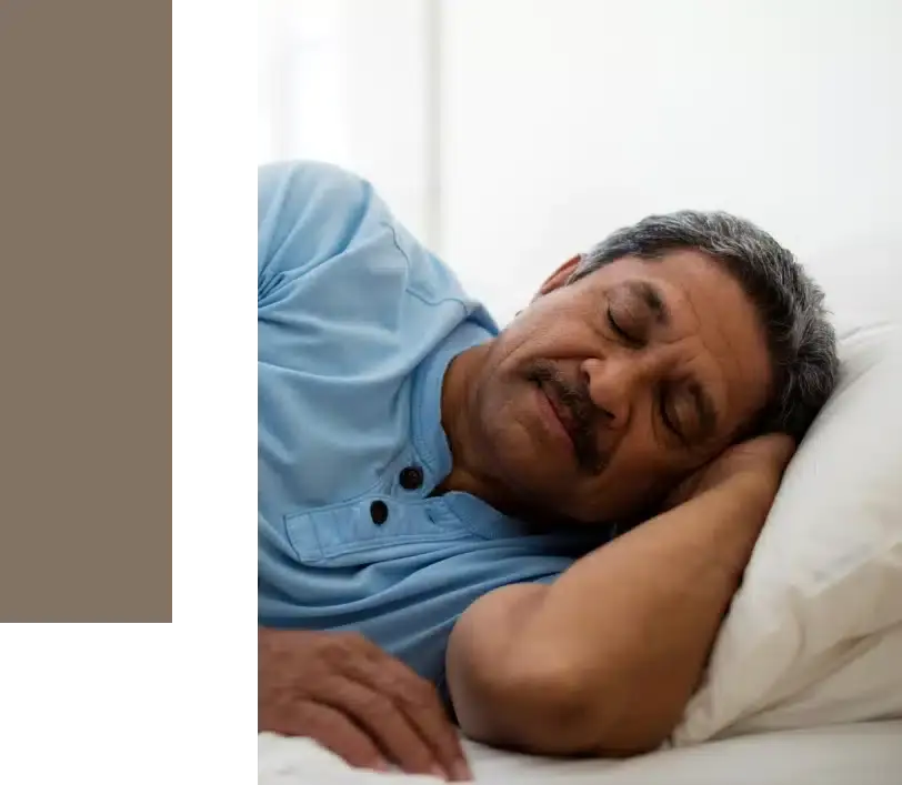 Man sleeping peacefully on white pillow, demonstrating restful sleep after sleep apnea treatment.